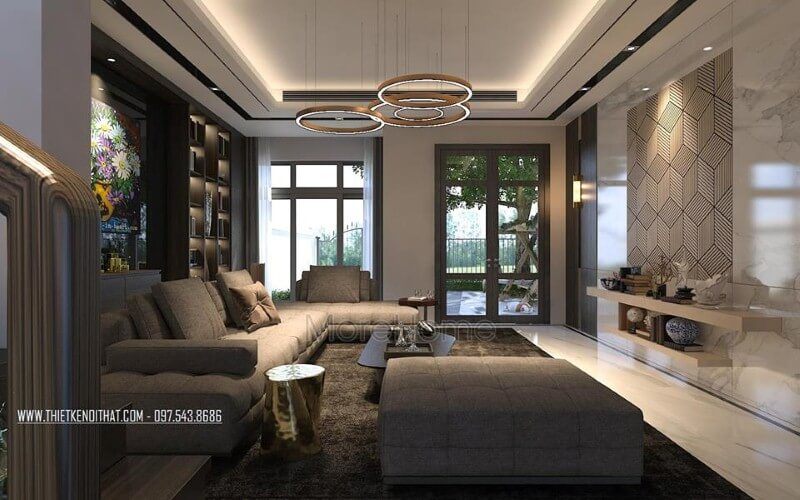 Sắp xếp nội thất phòng khách ấn tượng với cách kết hợp hài hòa giữa sắc trầm và sáng cùng hệ cửa kính lớn giúp không gian trở nên thông thoáng, sang trọng.